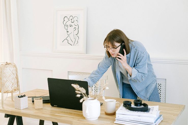 donna che telefona mentre controlla le email